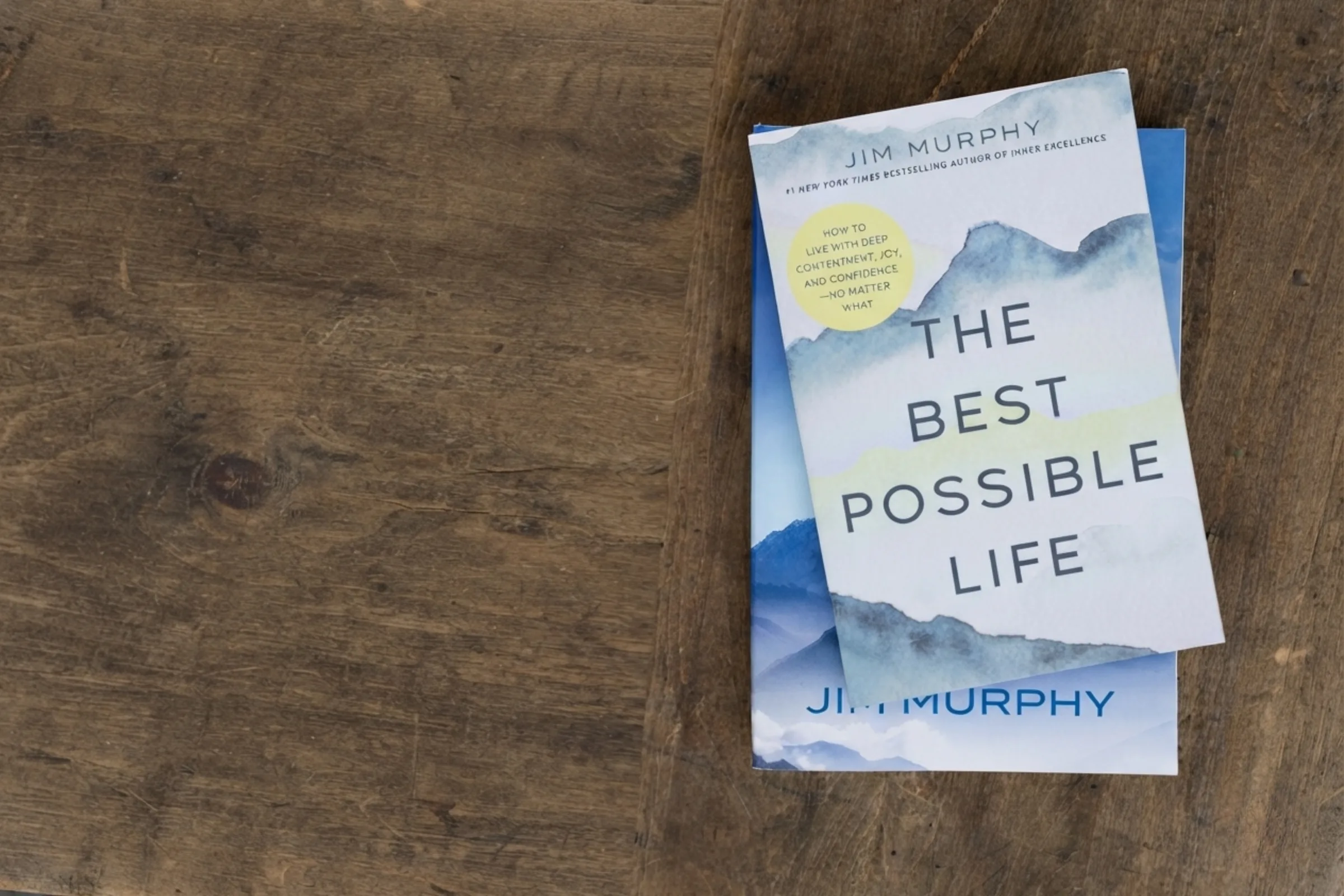 The Best Possible Life by Jim Murphy, resting on a copy of Inner Excellence