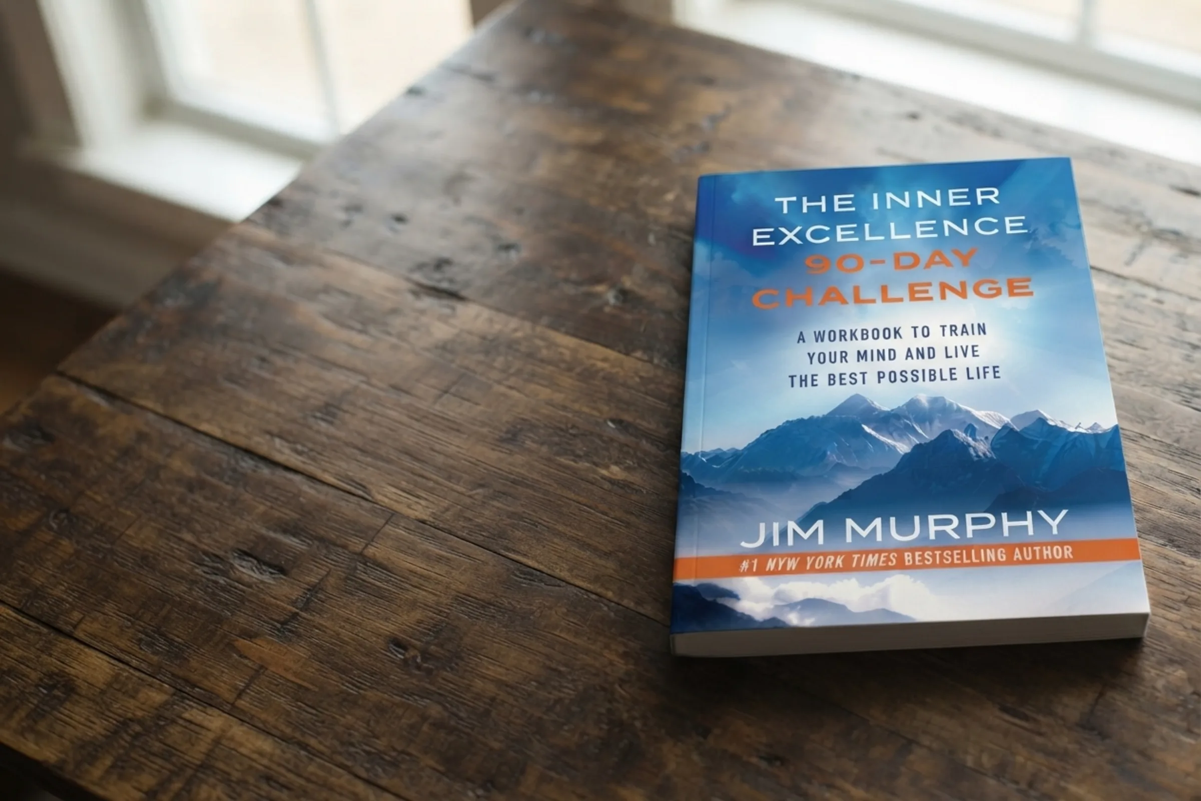 The Inner Excellence 90-Day Challenge workbook on a wooden table by a window