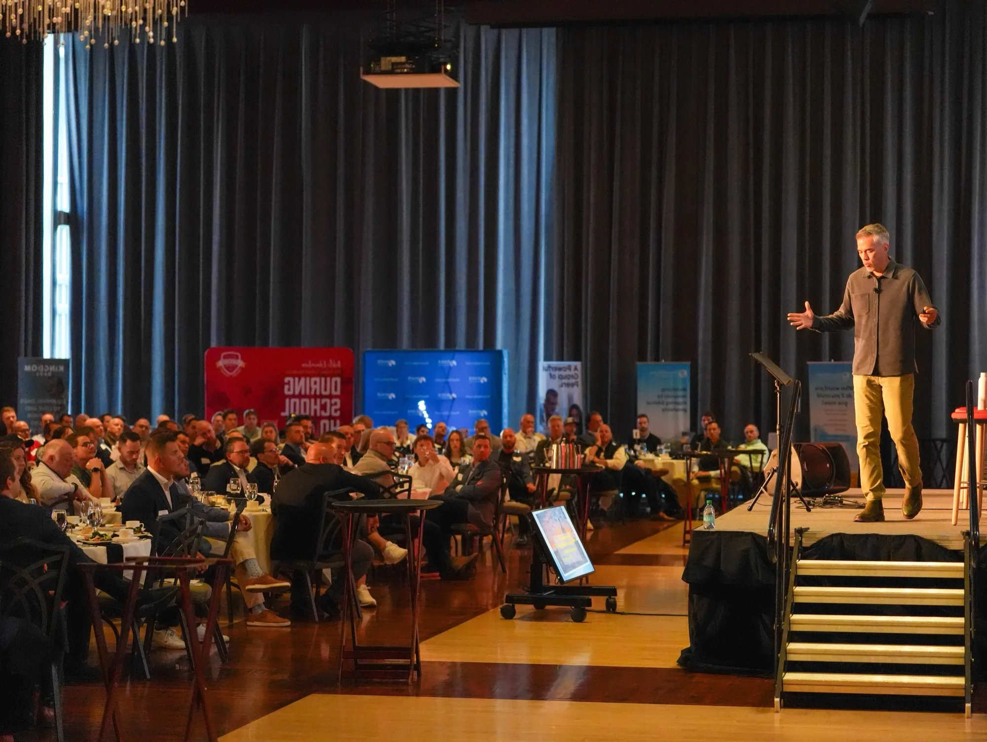Jim Murphy speaking on stage to a seated audience